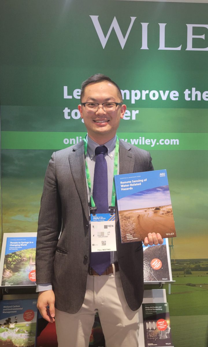 Mengye Chen holding the book Remote Sensing of Water-Related Hazards at AGU