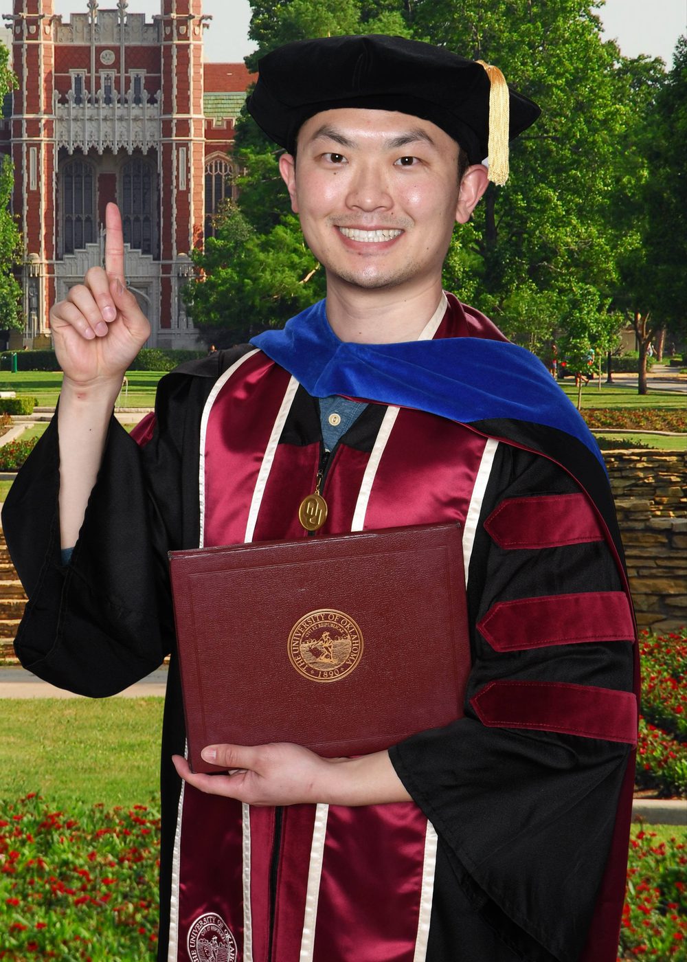 Mengye Chen in doctoral regalia on the University of Oklahoma campus